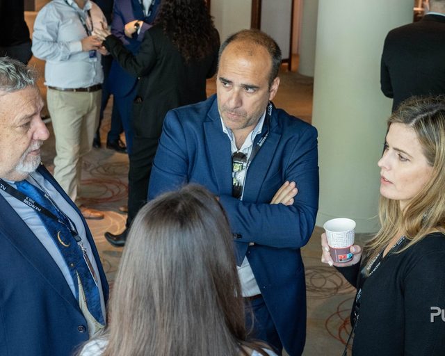 Three delegates talking together during a break at a previous Excellence in Digital Banking summit