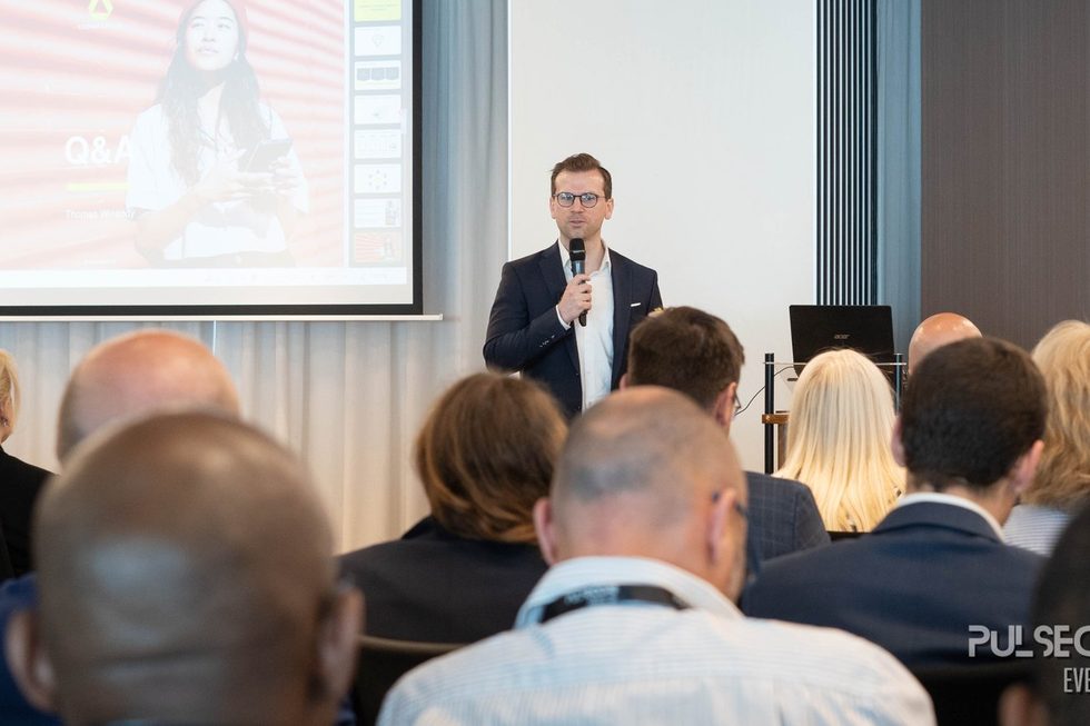 Delegates seated in front of a speaker presenting beside the screen at an Excellence in Digital Banking summit