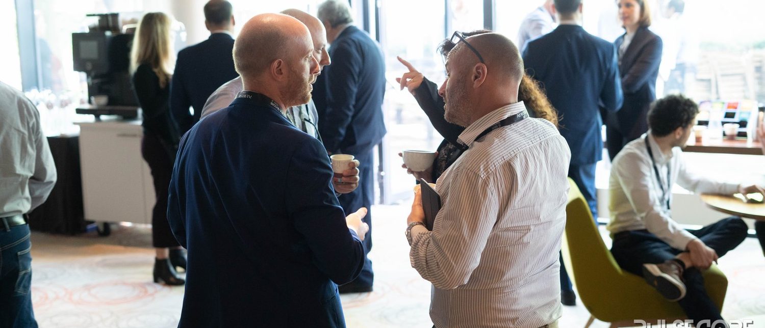 Delegates talking in a lounge area beside the conference room at an Excellence in Digital Banking summit